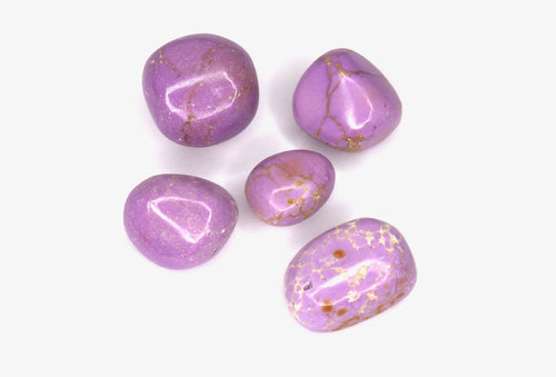 Purple gemstones with gold flecks on a white background