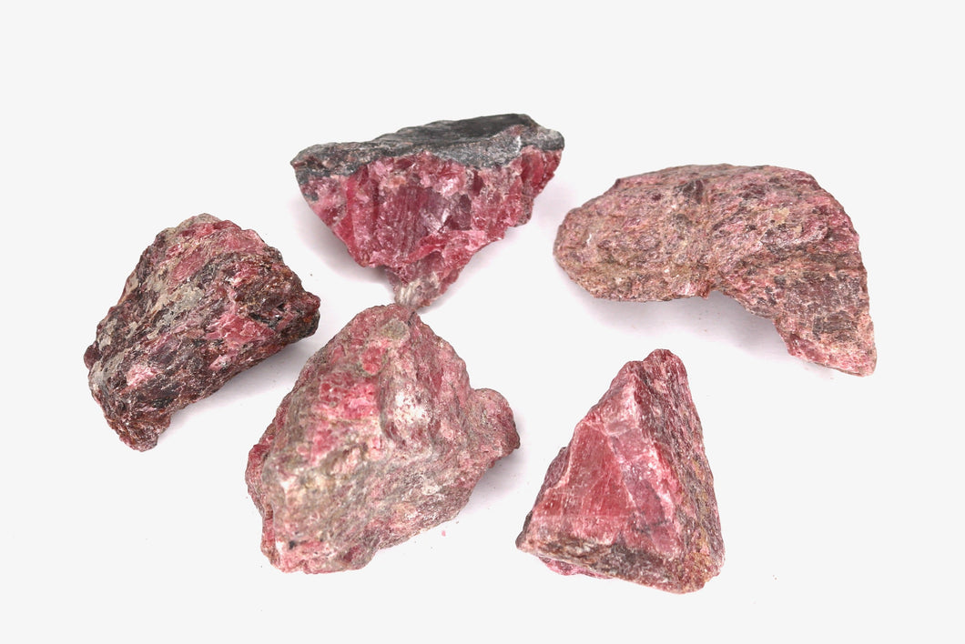 Five pinkish-red mineral specimens on a white background